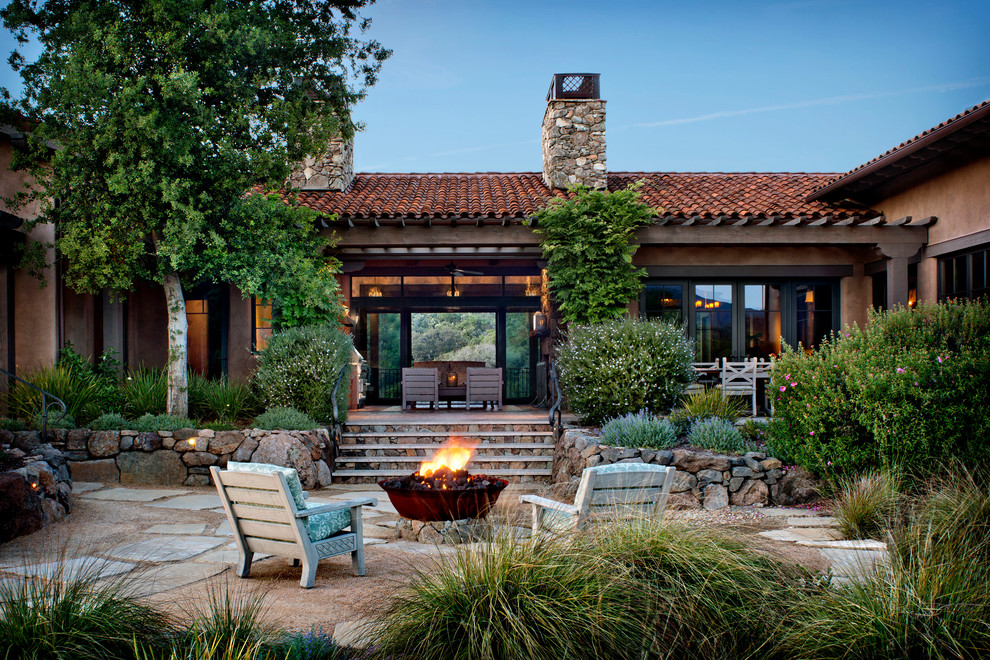 Diseño de patio de estilo americano grande sin cubierta en patio trasero con brasero y adoquines de piedra natural