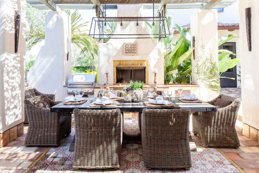 Immagine di un patio o portico mediterraneo in cortile con una pergola, un focolare e piastrelle