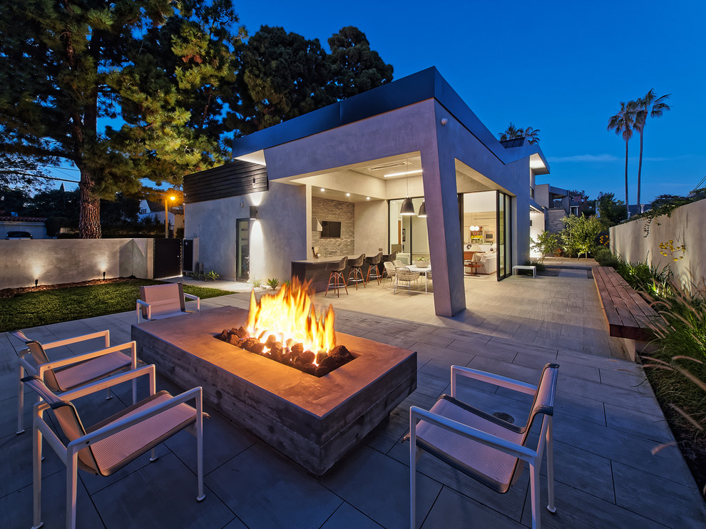 Großer, Unbedeckter Moderner Patio hinter dem Haus mit Feuerstelle und Natursteinplatten in Los Angeles