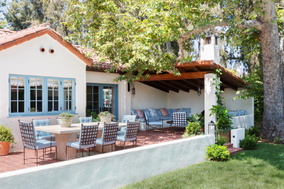 Inspiration for a mid-sized mediterranean backyard tile patio remodel in Los Angeles with a roof extension