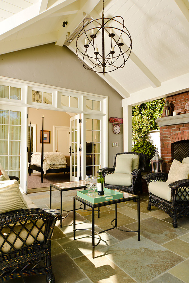 Immagine di un patio o portico minimal di medie dimensioni e dietro casa con un focolare, piastrelle e un parasole