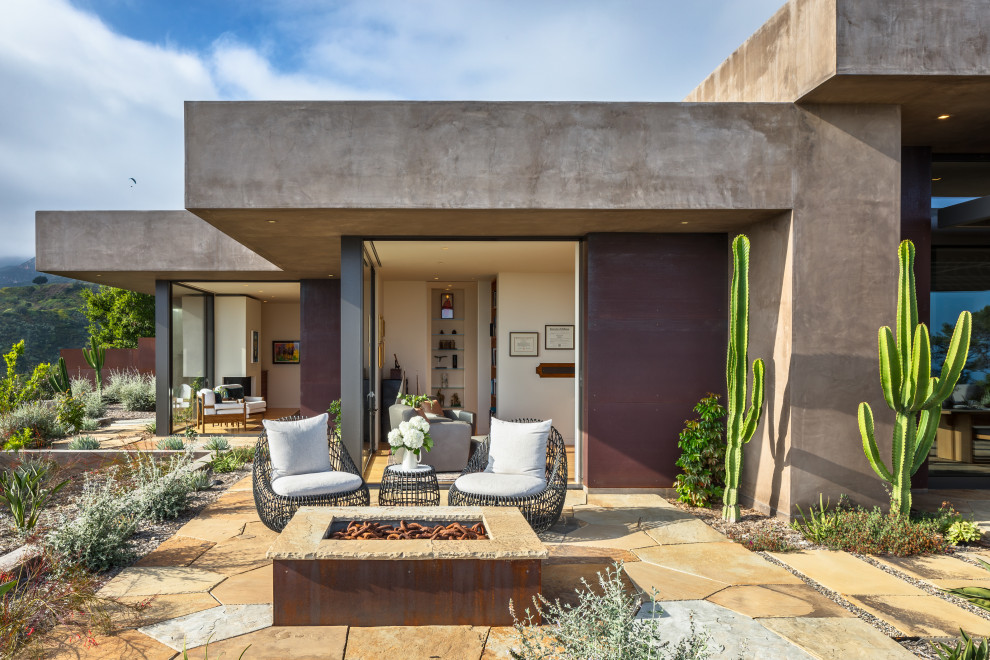 Cette image montre une terrasse sud-ouest américain avec un foyer extérieur, des pavés en pierre naturelle et aucune couverture.