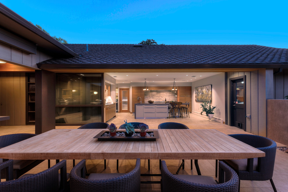 Стильный дизайн: двор среднего размера на внутреннем дворе в современном стиле с покрытием из плитки, летней кухней и навесом - последний тренд