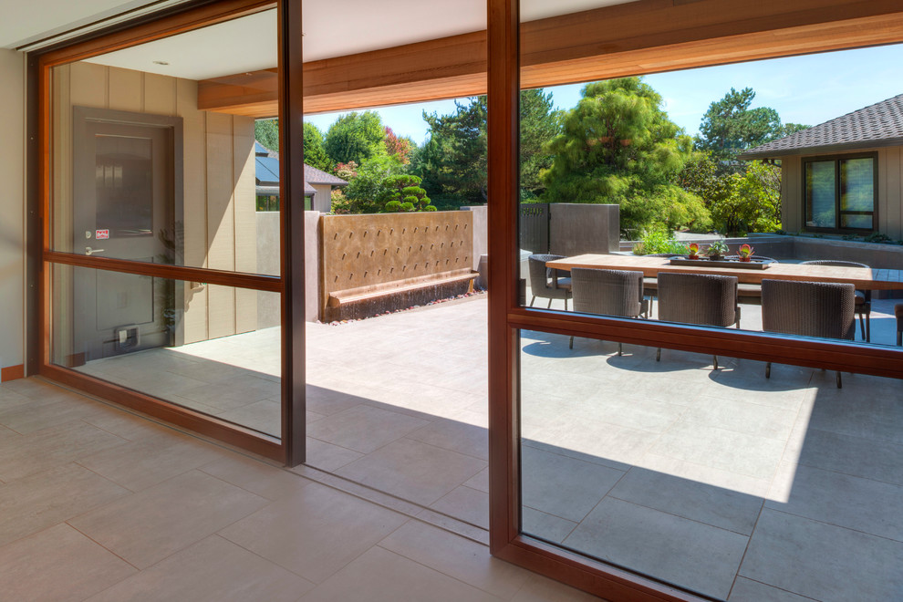 Medium sized contemporary courtyard patio in Portland with tiled flooring, an outdoor kitchen and a roof extension.
