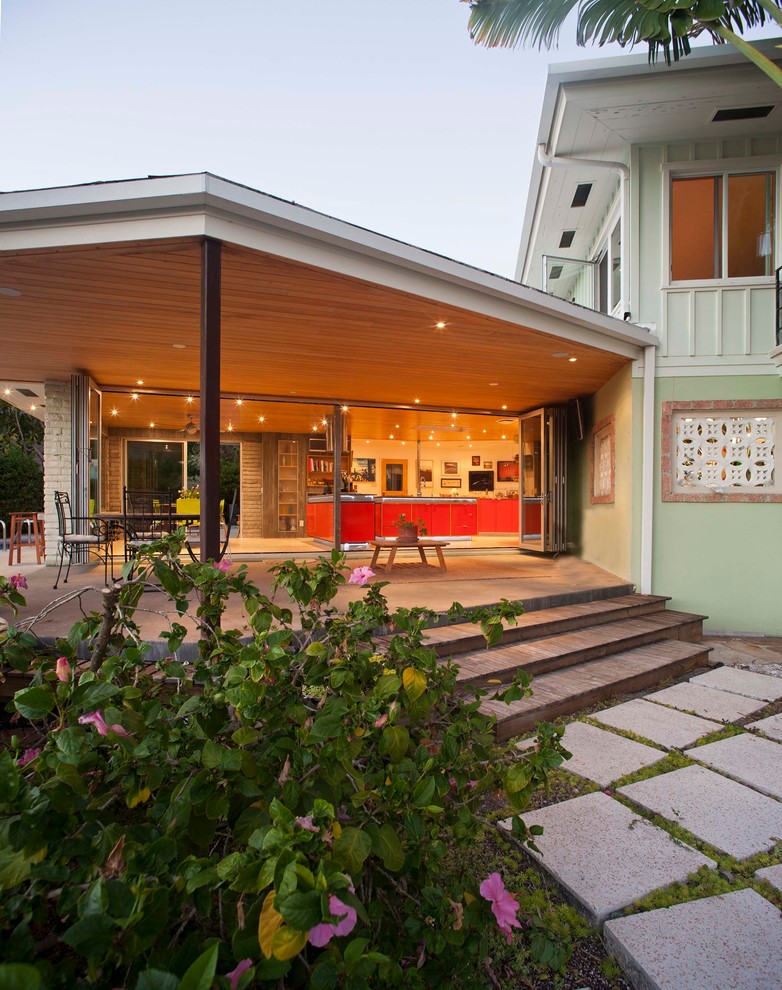 This is an example of a midcentury patio in Tampa with a roof extension.