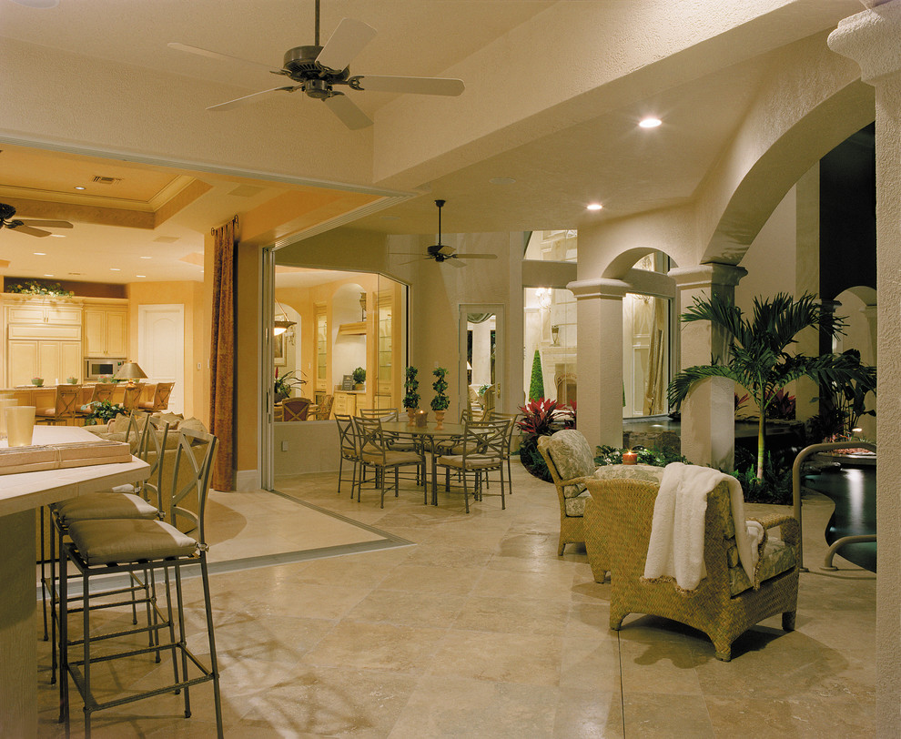 На фото: огромный двор на заднем дворе в средиземноморском стиле с летней кухней, покрытием из каменной брусчатки и навесом