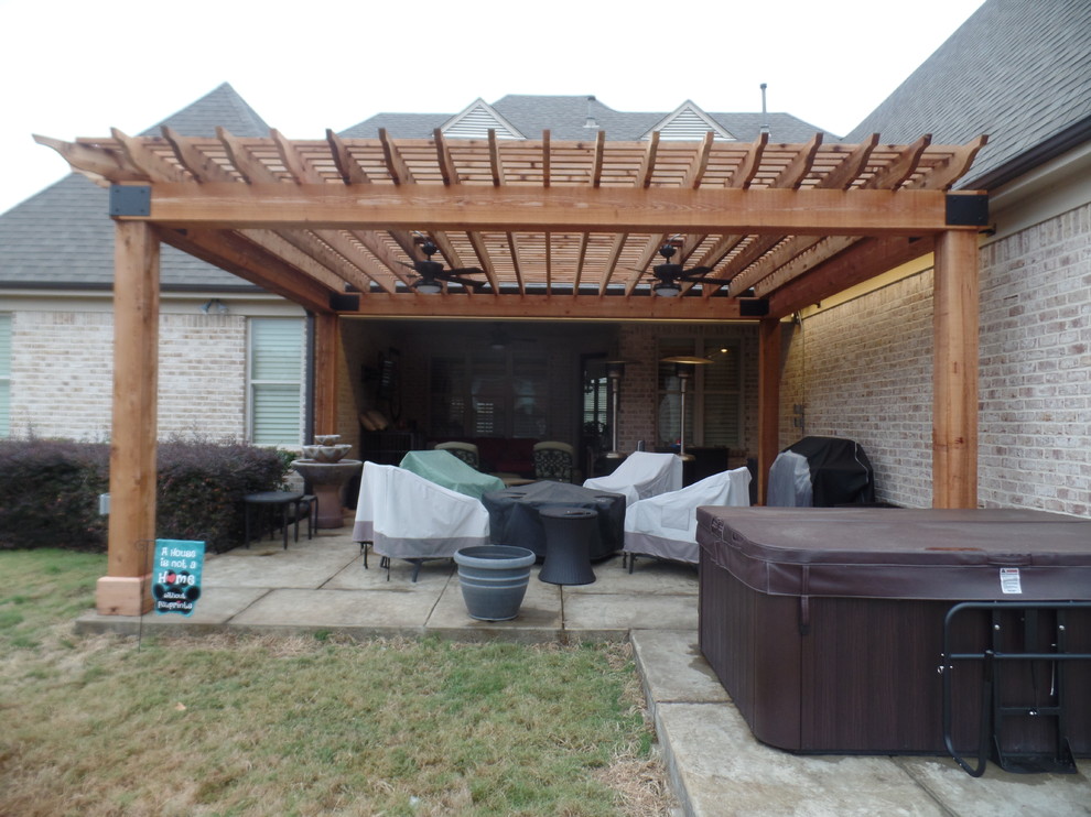Example of a large mountain style backyard stamped concrete patio design in Other with a pergola