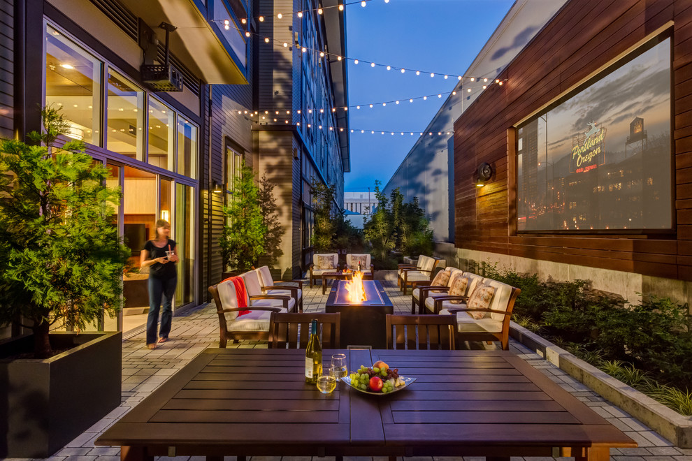 Design ideas for a large contemporary courtyard patio in Portland with a fire feature and concrete paving.