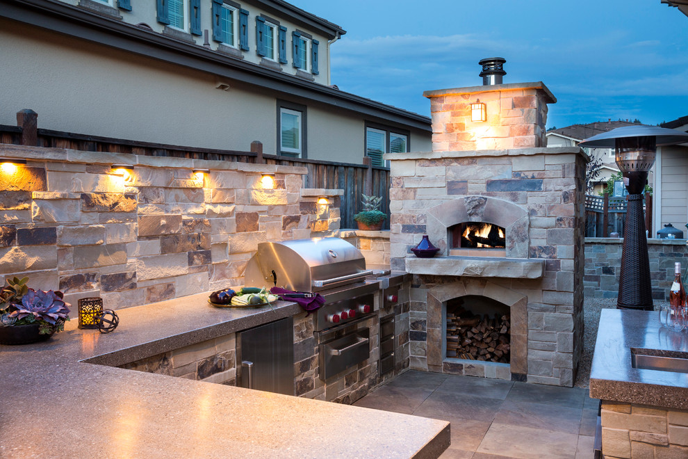 Foto de patio mediterráneo grande en patio trasero con cocina exterior, adoquines de piedra natural y pérgola