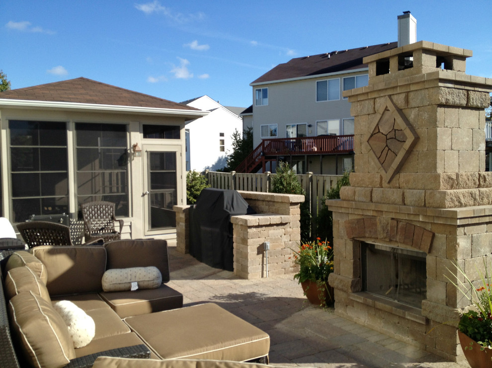 Foto di un grande patio o portico american style dietro casa con un focolare, pavimentazioni in mattoni e nessuna copertura