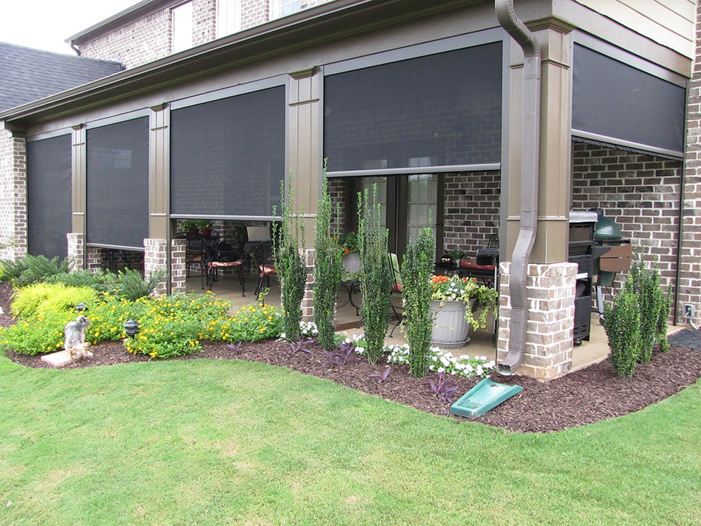 Cette photo montre une terrasse arrière chic de taille moyenne avec une cuisine d'été, une dalle de béton et une extension de toiture.