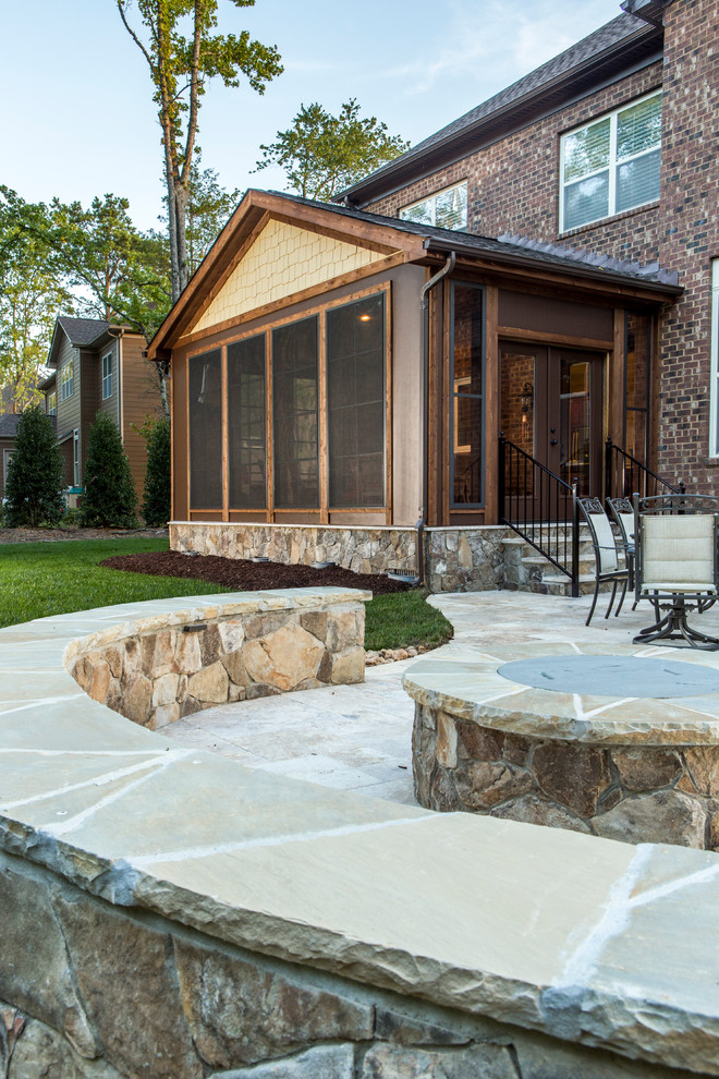 Cette image montre une terrasse en bois arrière traditionnelle avec un foyer extérieur et une extension de toiture.