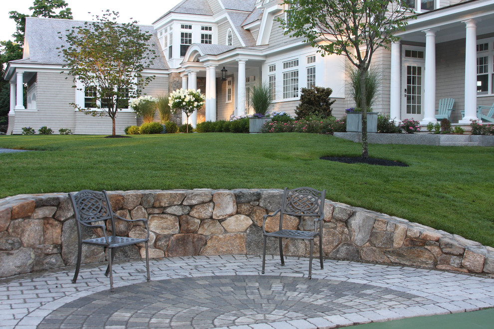 Пример оригинального дизайна: большой двор на переднем дворе в морском стиле с мощением тротуарной плиткой