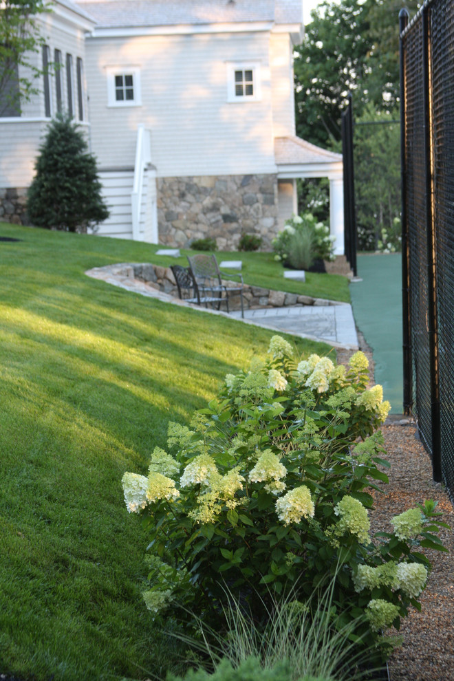 This is an example of a large coastal side patio in Boston with concrete paving.