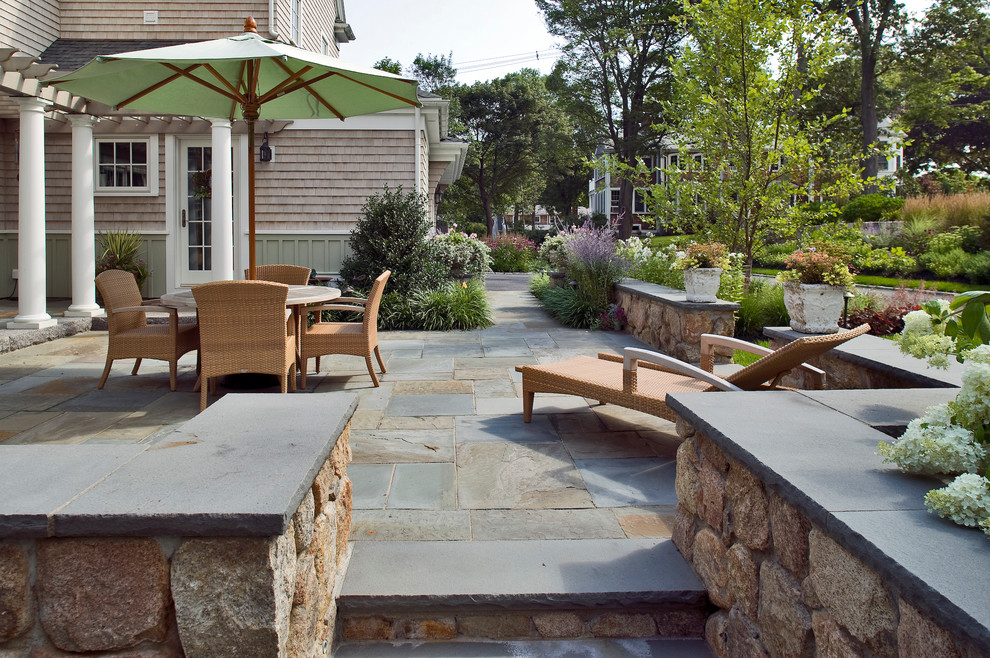 This is an example of a traditional patio in Boston with a pergola.