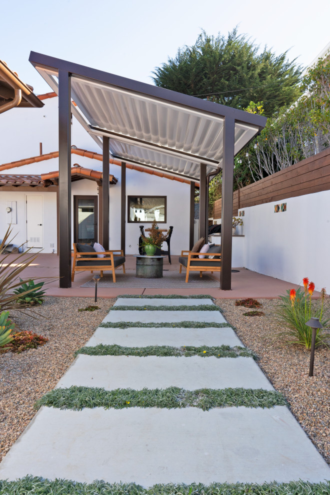 Idée de décoration pour une terrasse arrière méditerranéenne de taille moyenne avec une cuisine d'été, une dalle de béton et une pergola.