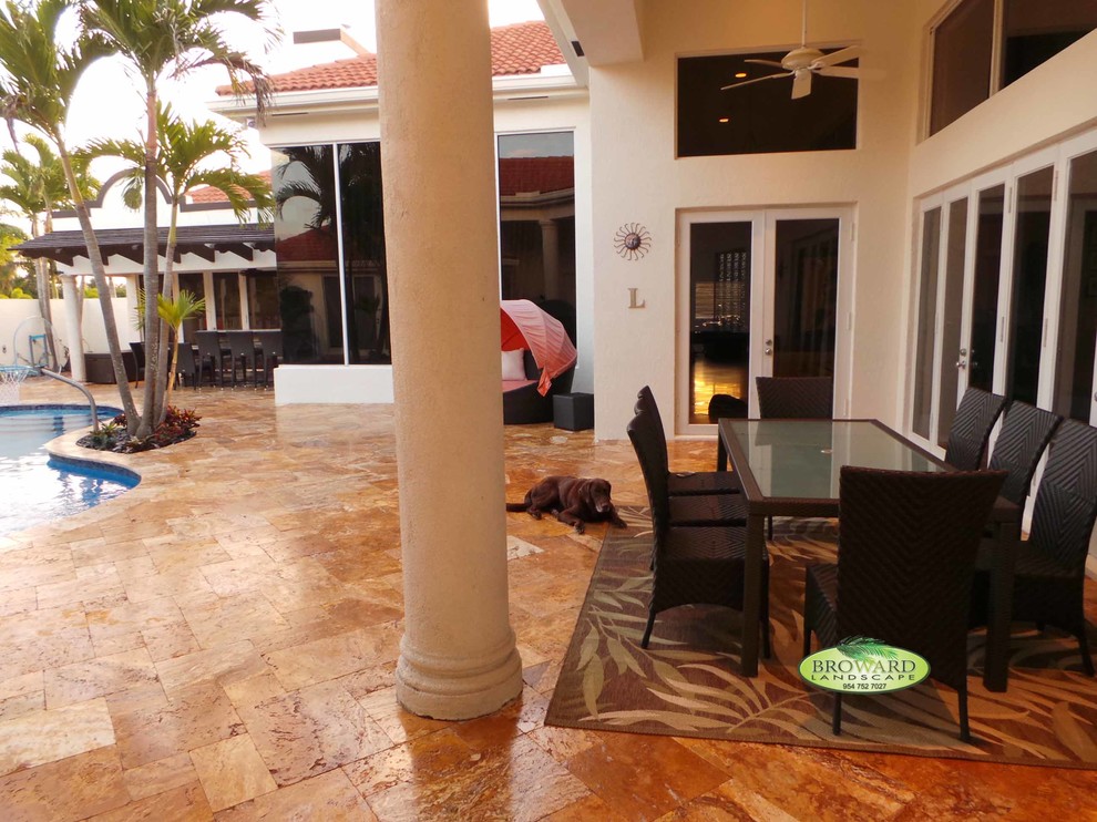 Large island style backyard stone patio photo in Miami with no cover