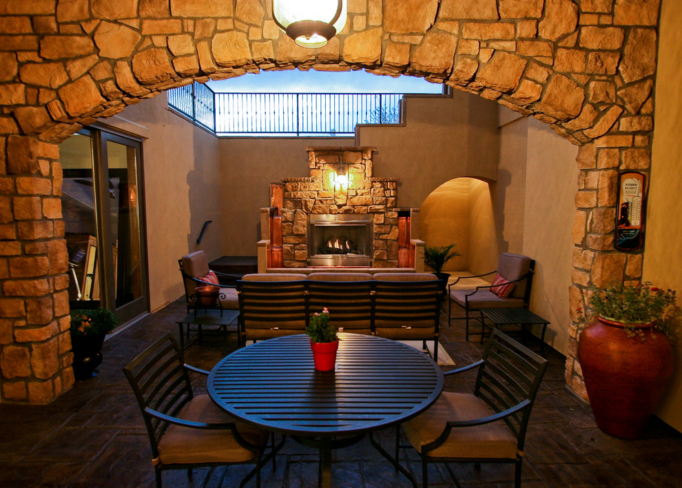 Foto di un patio o portico tradizionale di medie dimensioni e dietro casa con un focolare, pavimentazioni in mattoni e nessuna copertura