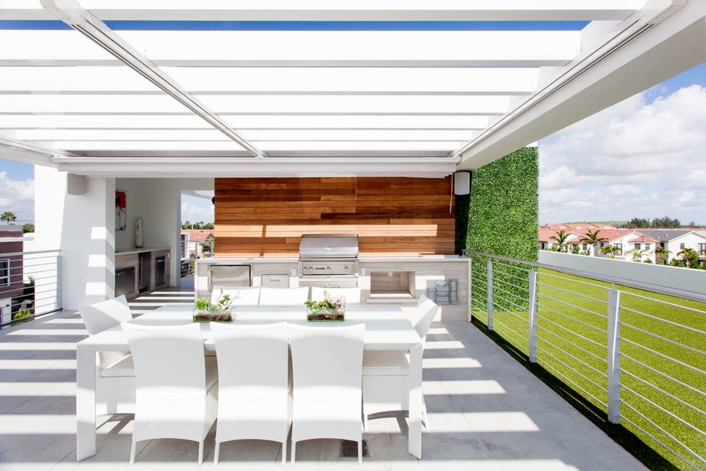 Idée de décoration pour une terrasse arrière design de taille moyenne avec une cuisine d'été, des pavés en béton et une pergola.