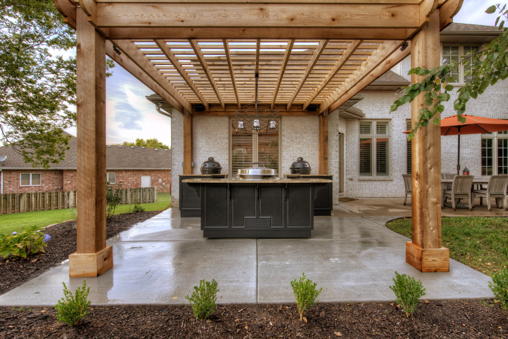 Idee per un grande patio o portico chic dietro casa con lastre di cemento e una pergola