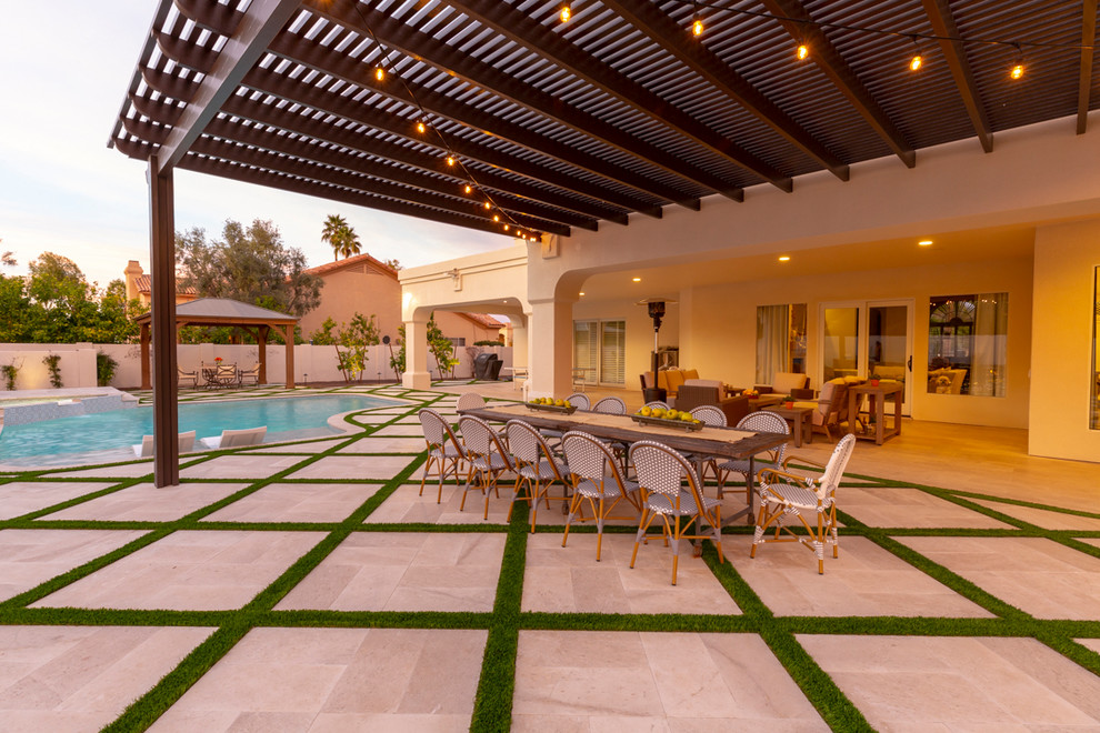 Immagine di un patio o portico minimal di medie dimensioni e dietro casa con pavimentazioni in pietra naturale e una pergola