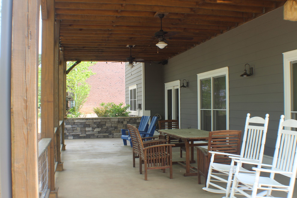 Ejemplo de patio de estilo americano grande en patio trasero y anexo de casas con losas de hormigón
