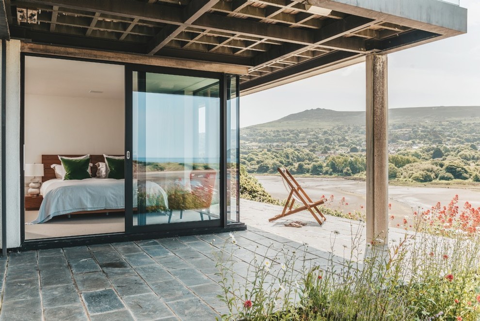 Inspiration pour une terrasse arrière marine de taille moyenne avec des pavés en pierre naturelle et une extension de toiture.
