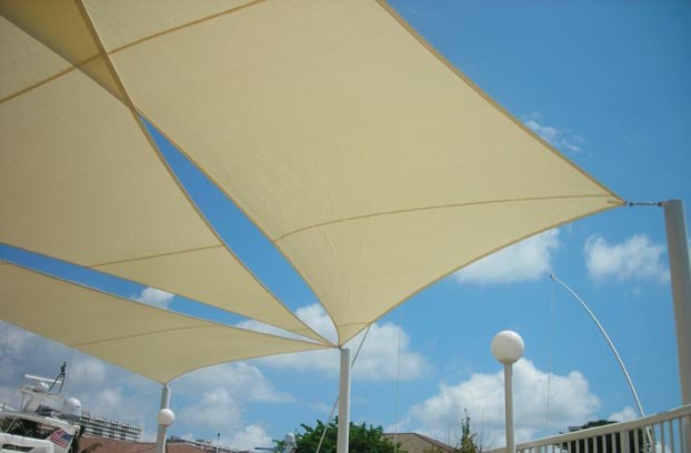 This is an example of a large world-inspired back patio in Miami with an awning.