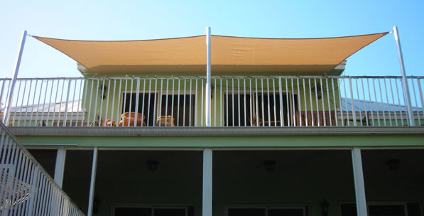 Esempio di un patio o portico tropicale di medie dimensioni con un parasole