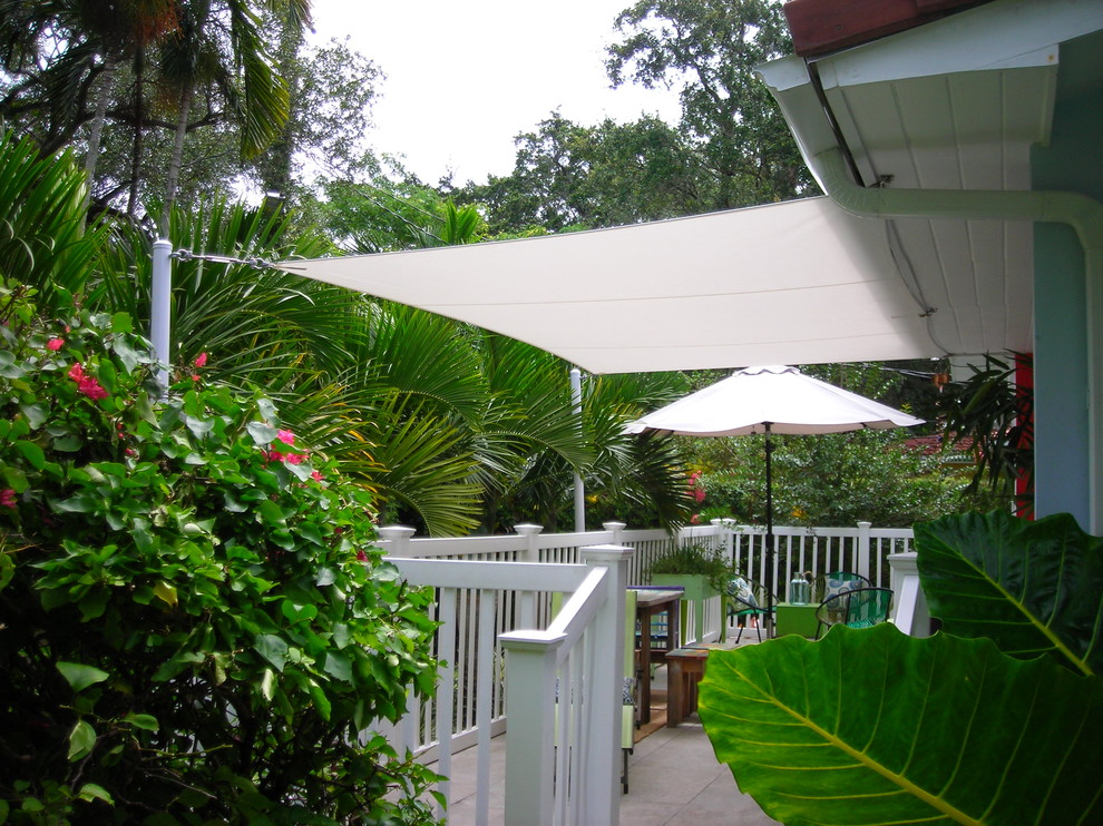 Idee per un piccolo patio o portico tropicale dietro casa con un parasole
