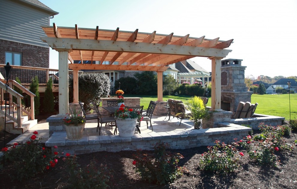 Diseño de patio clásico grande en patio trasero con brasero, adoquines de ladrillo y pérgola