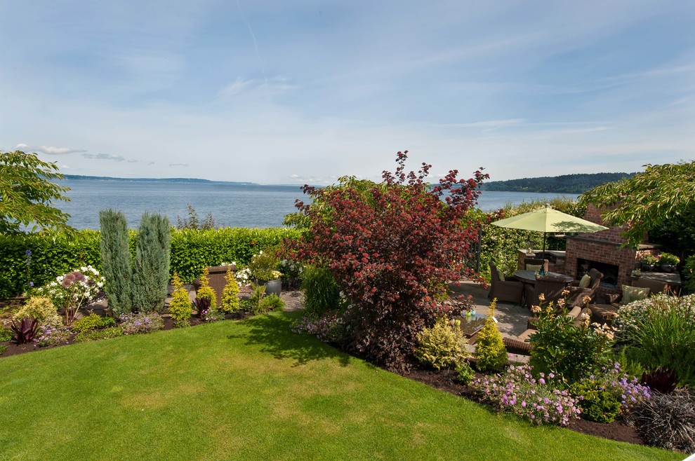 Large contemporary back patio in Seattle with concrete paving, a fire feature and no cover.