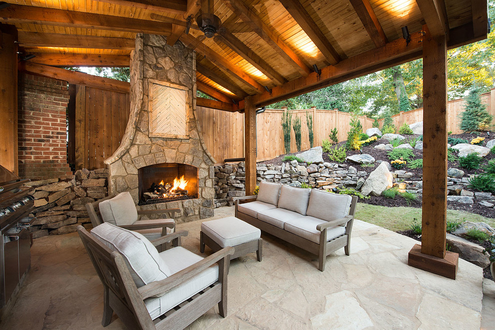 Foto di un grande patio o portico american style dietro casa con un focolare, pavimentazioni in pietra naturale e un gazebo o capanno