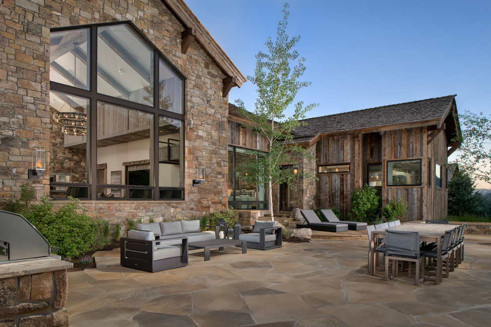 Inspiration for a rustic backyard stone patio remodel in Other with no cover