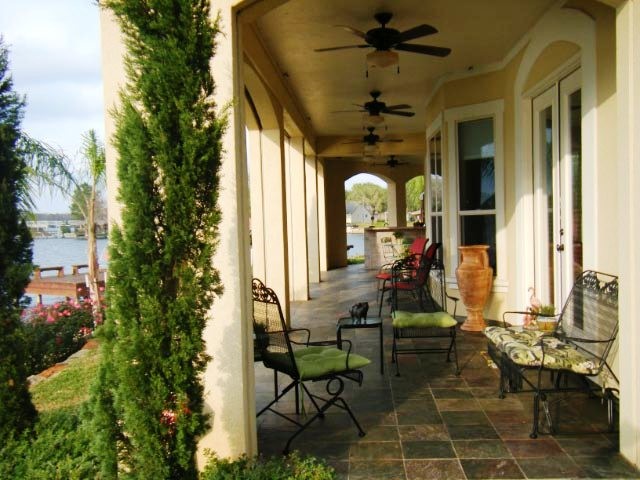 Immagine di un patio o portico mediterraneo di medie dimensioni e dietro casa con piastrelle e un tetto a sbalzo