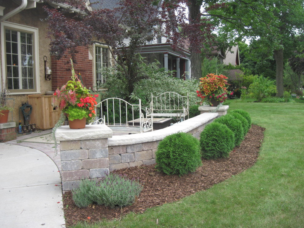Design ideas for a medium sized traditional front patio in Milwaukee with natural stone paving and no cover.