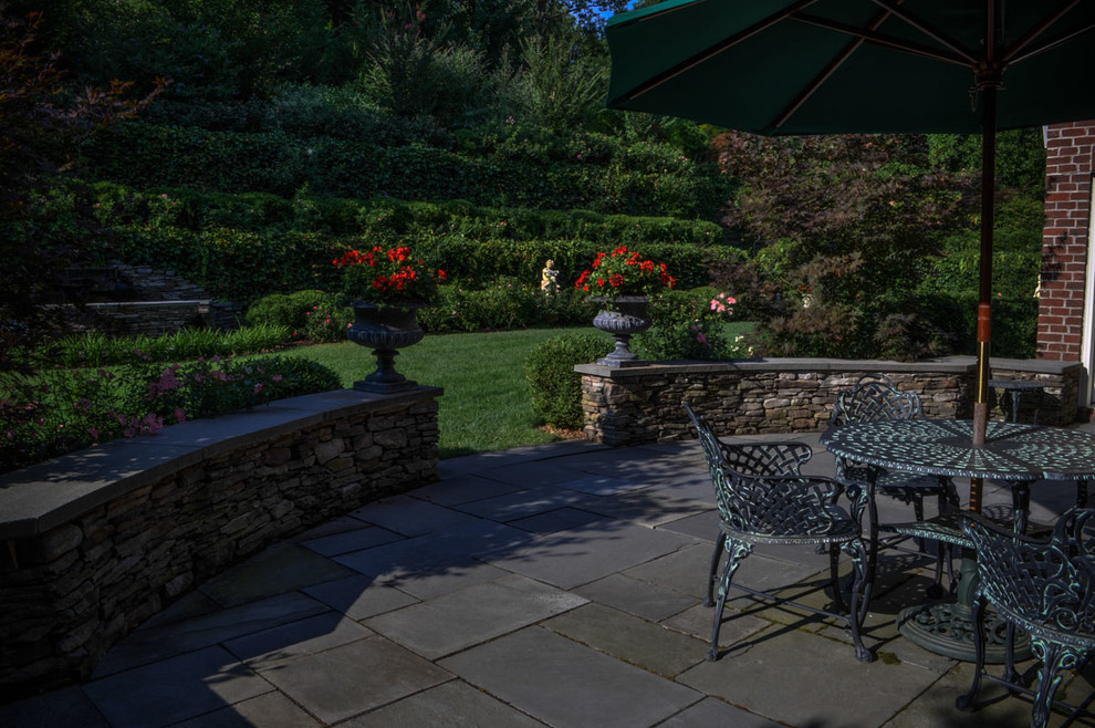 Mid-sized elegant backyard stone patio photo in New York with no cover