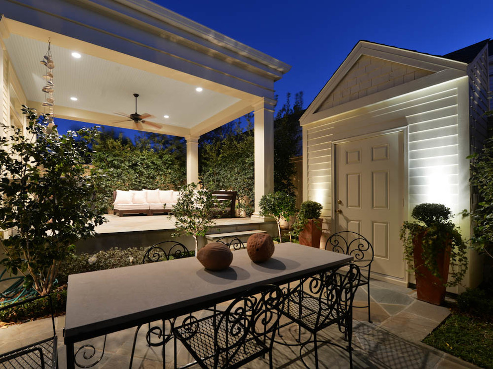 Aménagement d'une terrasse arrière classique de taille moyenne avec des pavés en pierre naturelle et une extension de toiture.