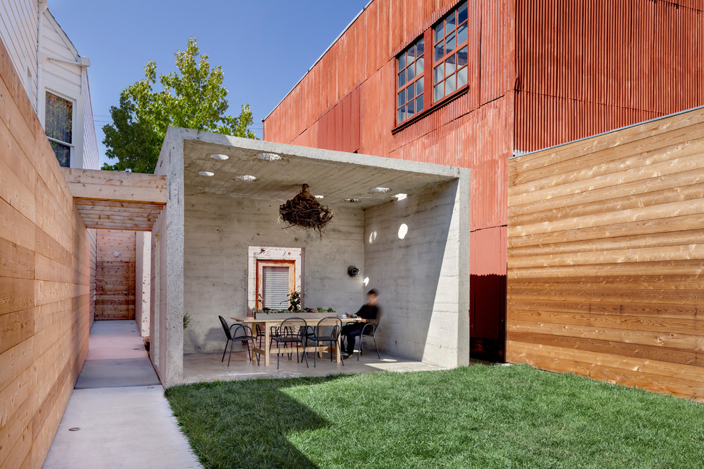 Patio - industrial concrete patio idea in San Francisco with a roof extension