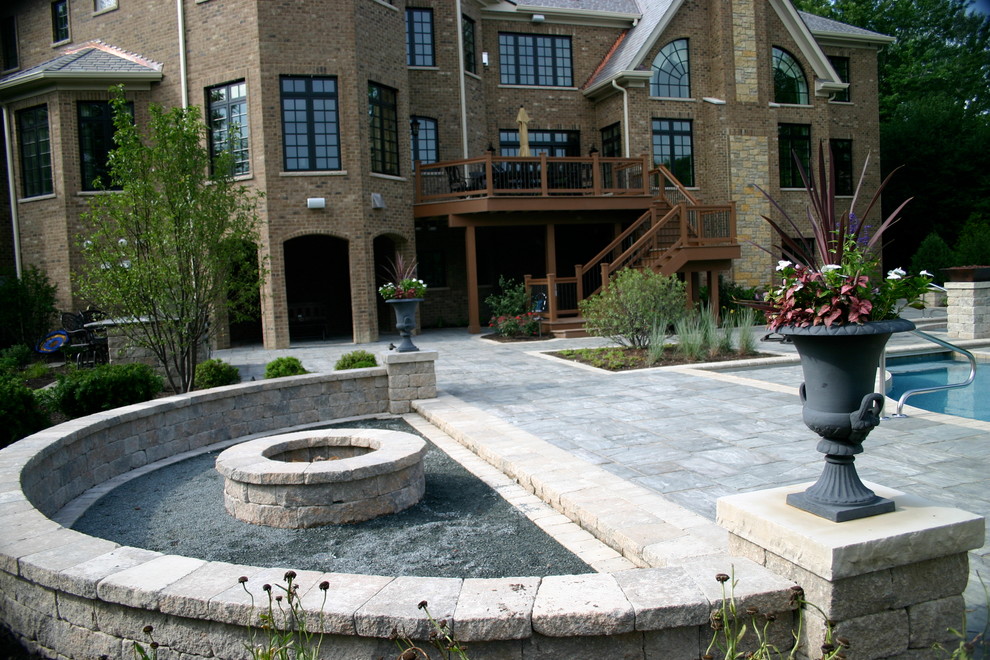 Example of a large classic backyard concrete paver patio design in Chicago with a fire pit and a pergola