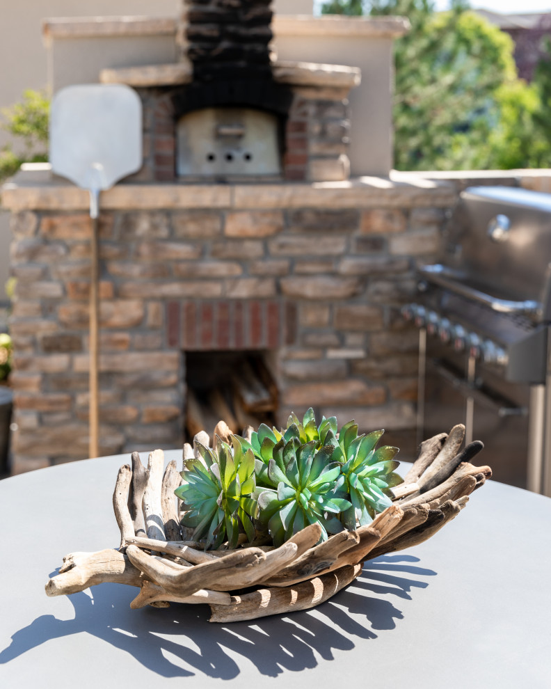 Exemple d'une grande terrasse arrière chic avec une cuisine d'été, des pavés en béton et une pergola.