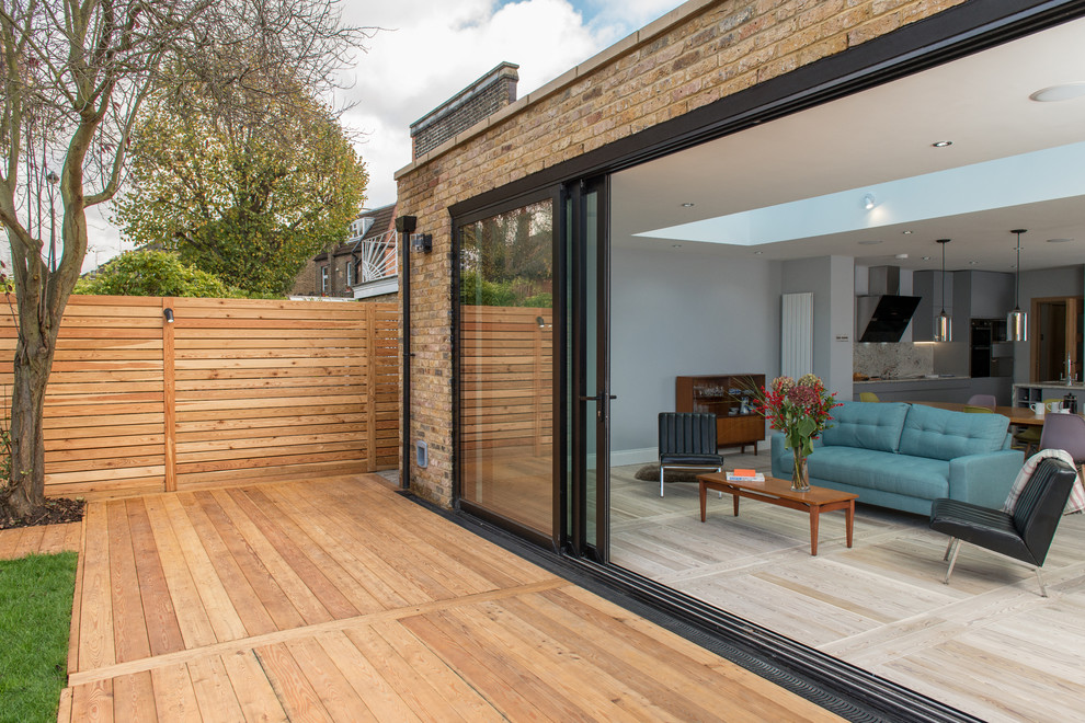 Inspiration for a medium sized contemporary back patio in London with decking.