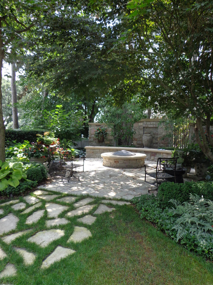 Imagen de patio tradicional renovado de tamaño medio sin cubierta en patio trasero con brasero y adoquines de piedra natural