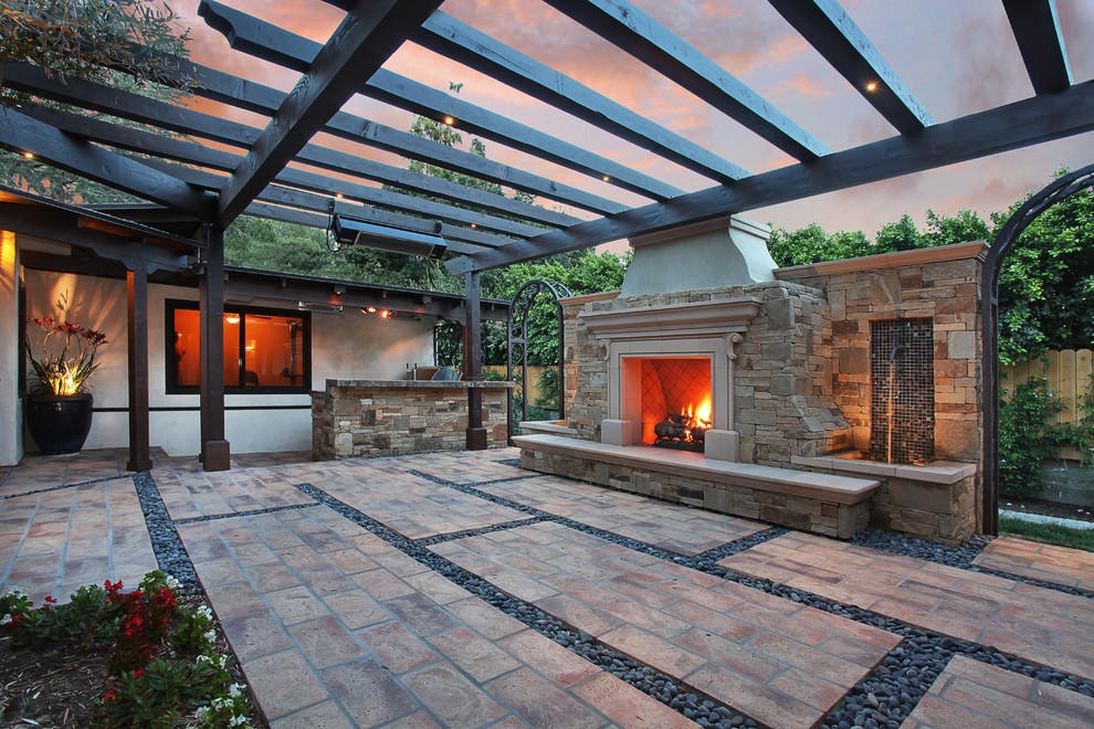 Diseño de patio mediterráneo de tamaño medio en patio con brasero, adoquines de piedra natural y cenador