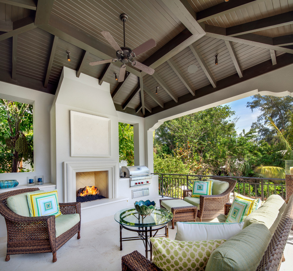 Exemple d'une grande terrasse arrière chic avec un foyer extérieur, des pavés en pierre naturelle et une pergola.