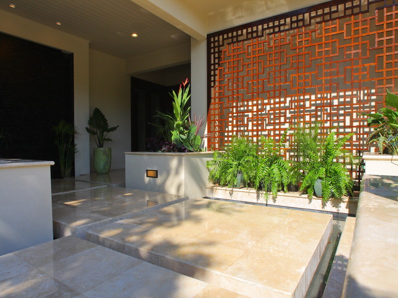 Example of a zen front yard tile patio fountain design in Tampa with a roof extension