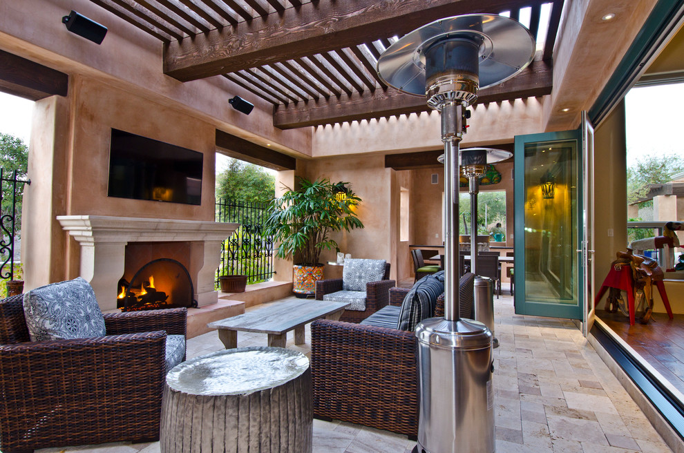 Idée de décoration pour une terrasse arrière sud-ouest américain de taille moyenne avec un foyer extérieur, des pavés en pierre naturelle et une pergola.