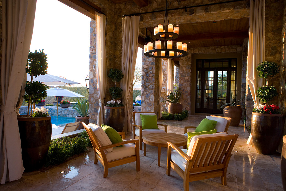 Photo of a mediterranean patio in Phoenix with a roof extension.