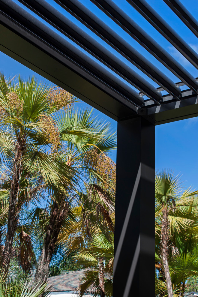 Große Industrial Pergola hinter dem Haus mit Outdoor-Küche und Natursteinplatten in Orlando