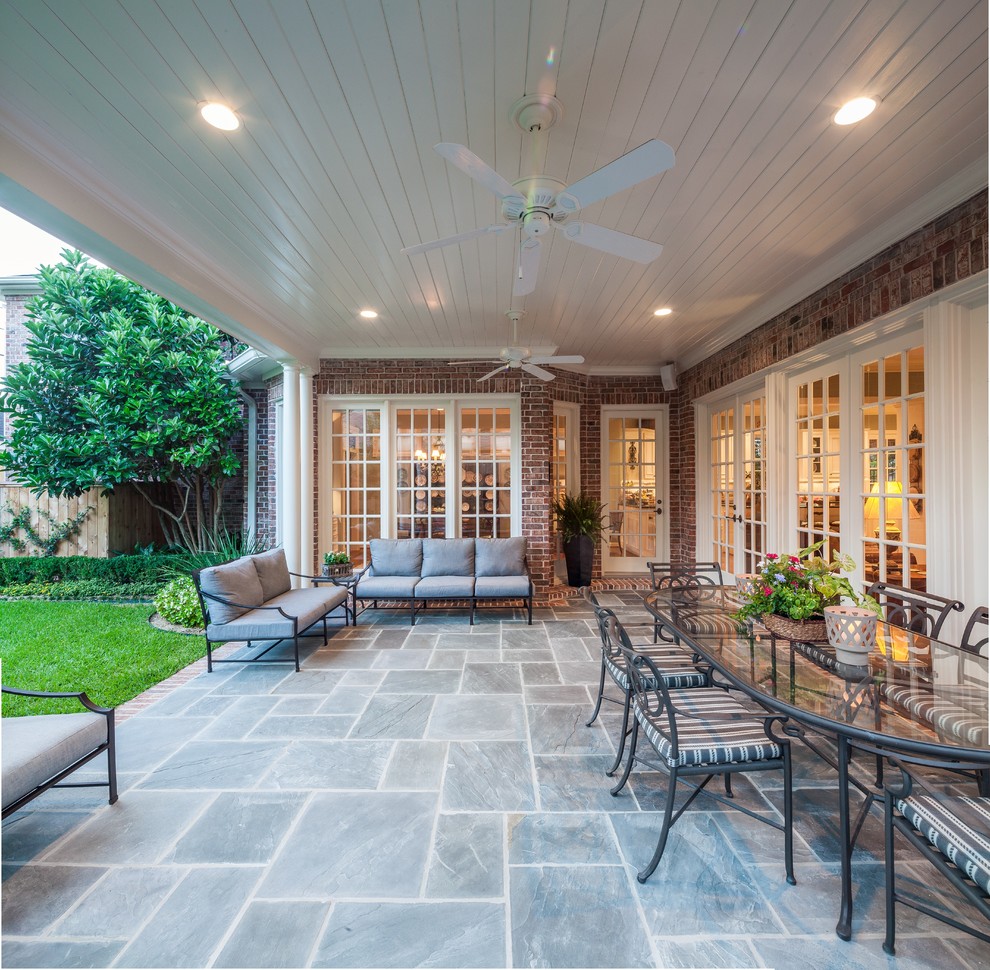 Inspiration for a large classic back patio in Houston with tiled flooring and a roof extension.